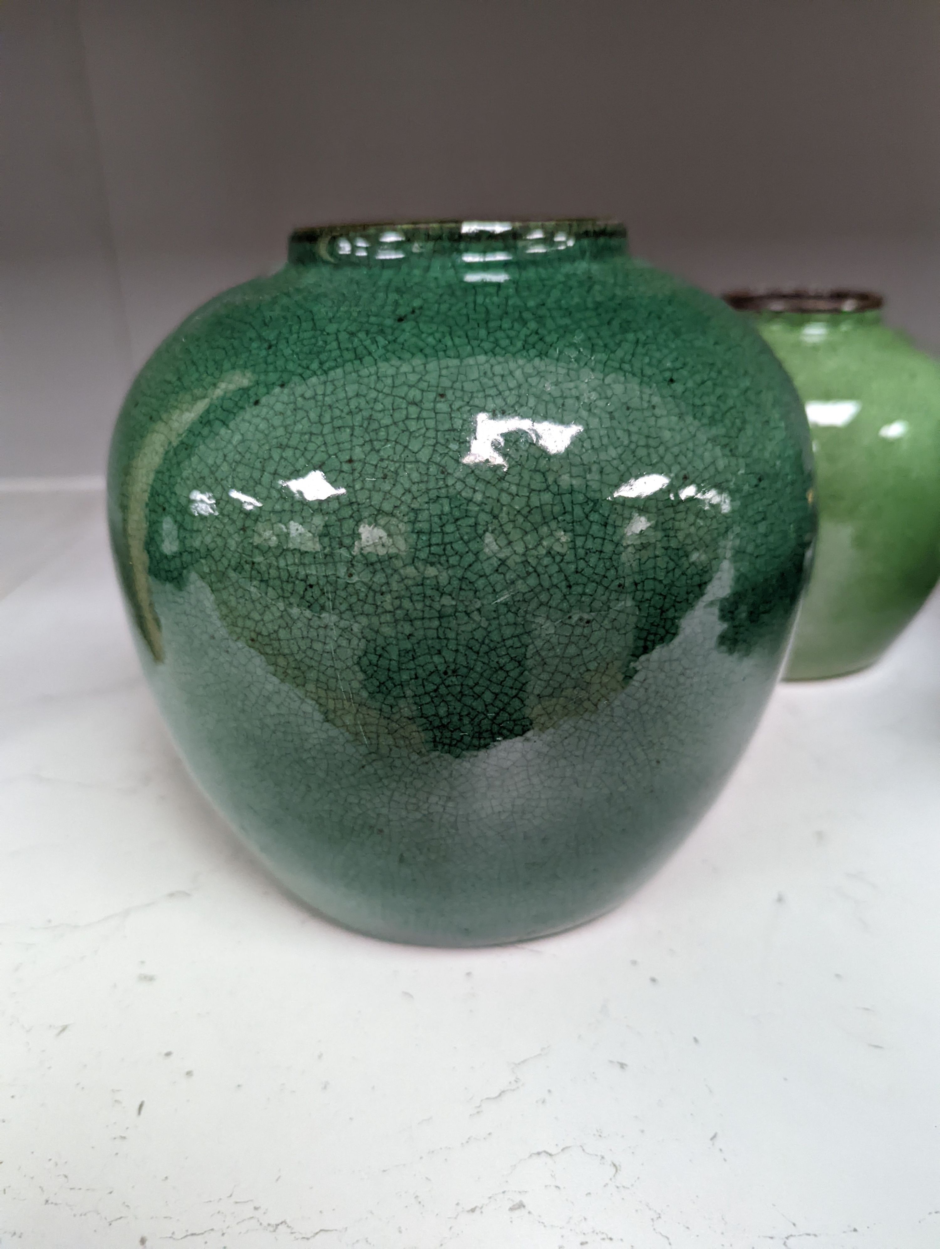 A 19th century Chinese green glazed model of a lion-dog, and two green crackle glaze jars, tallest 16cm